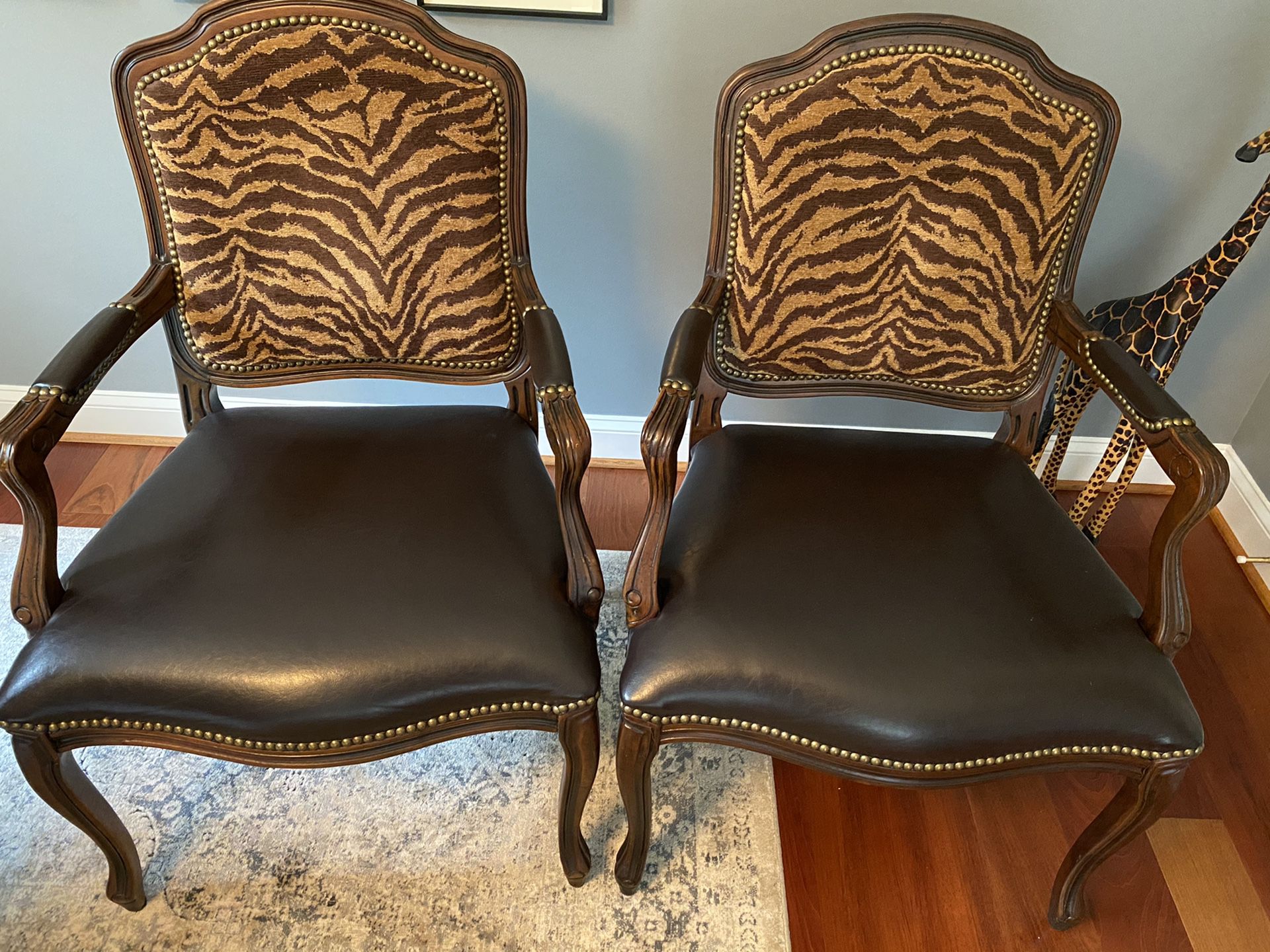 Occasional Chairs with animal print backs and rich leather seats.