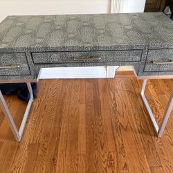 Desk in a gray textured faux-reptile finish 