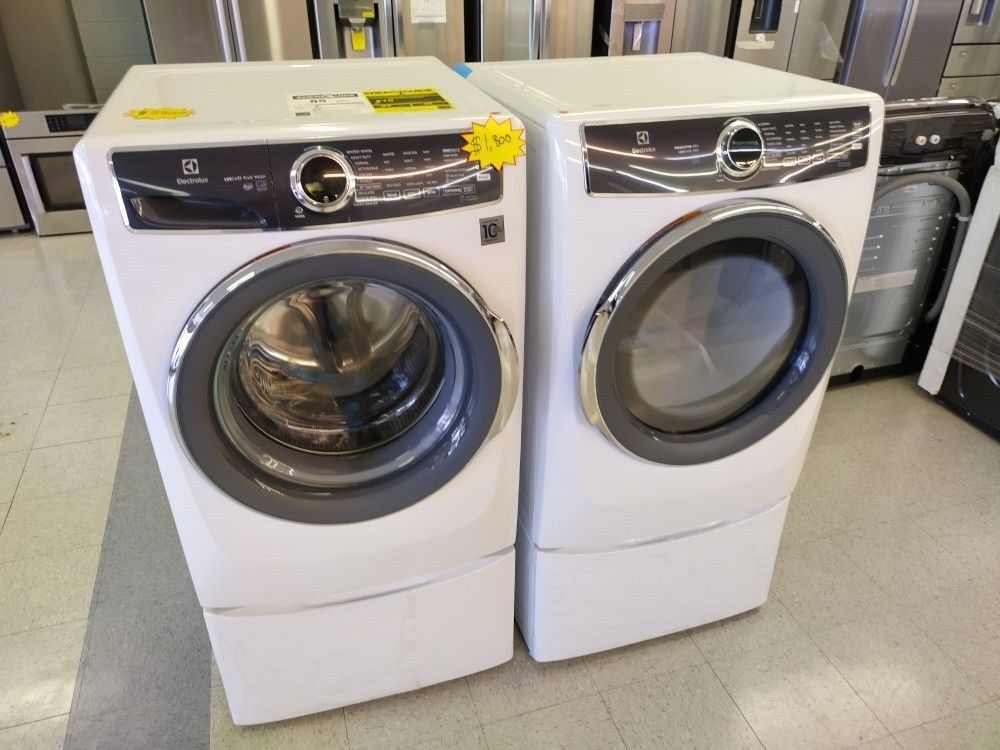ELECTROLUX WASHER AND ELECTRIC DRYER ON PEDESTALS