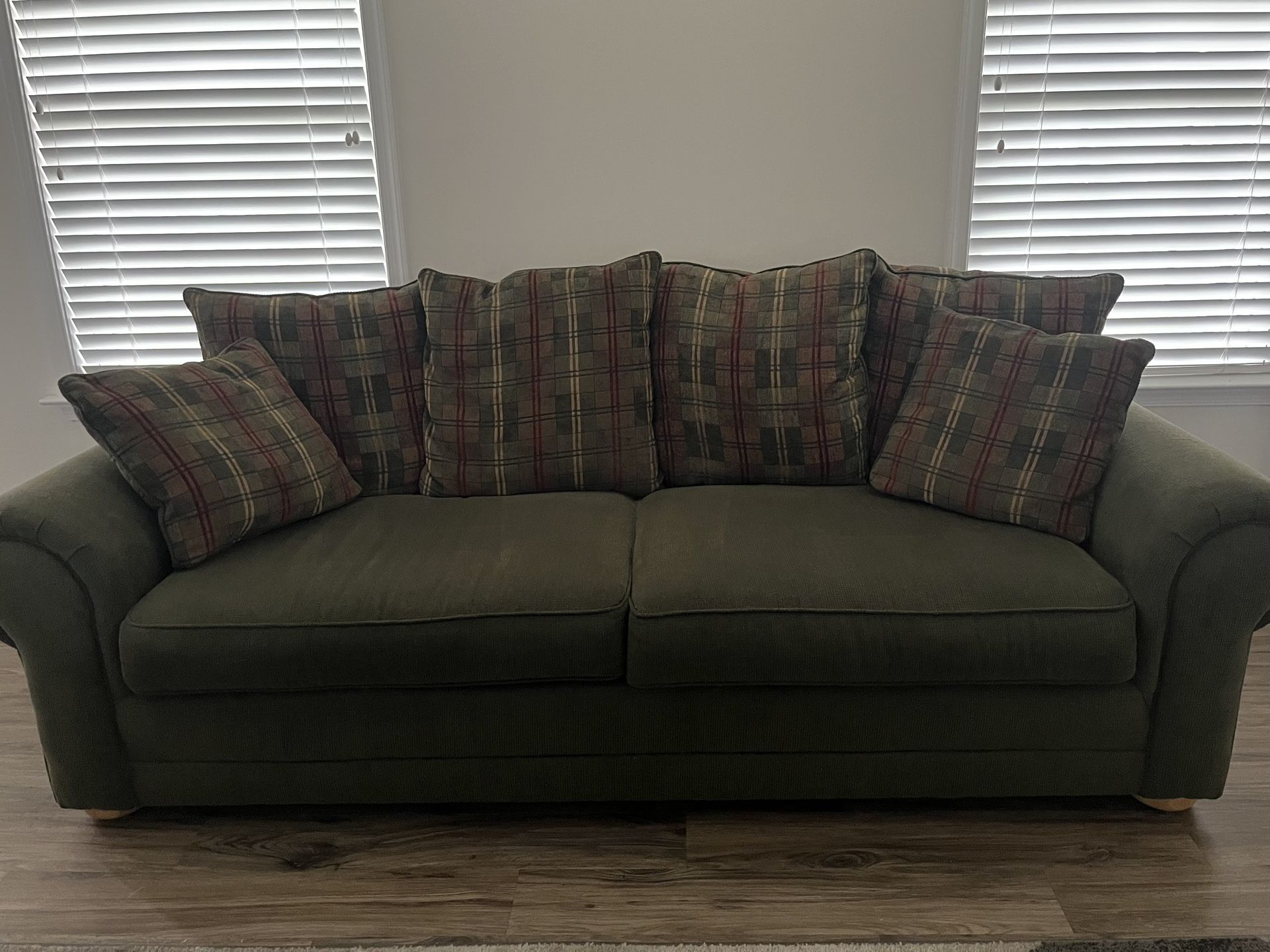 Comfortable Deep Green Sofa with Plaid Pillows