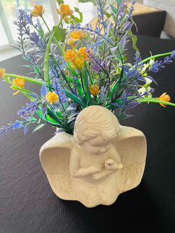Adorable ceramic angel planter. Has artificial yellow and purple flowers. Angel holds a small bird.