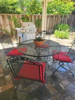 Used wrought iron patio table and chairs with pillows