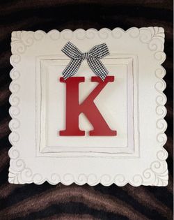 Monogram plaque with red capital letter "K" accented with a gingham fabric  black-and-white checkered bow