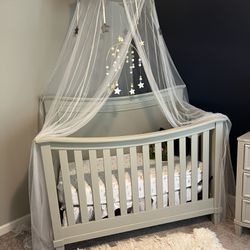 gray nursery set that includes crib, mattress, dresser with built in changing table