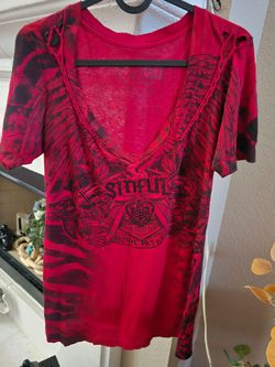 Bold red Affliction tee with dark graphic print. Soft fabric and classic crew neck. Striking, casual style.
The top is the red "Ayala" rhinestone t-sh