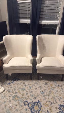two ivory wing back chairs