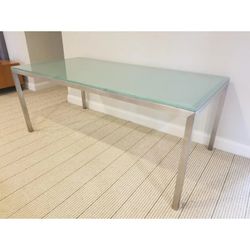 Modern dining table features a sleek stainless steel frame and a frosted glass top W62" D36" H29"