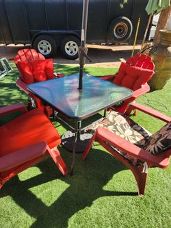 Patio table with 4 plastic chairs and umbrella