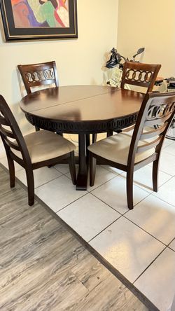 Large round dark wood table with four matching chair chairs