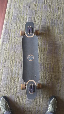Arbor brand drop-through longboard with a kicktail and vintage-style graphic, sometimes found with harder wheels intended for freeriding