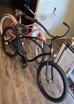 Two Electra beach cruisers one all black and one pink