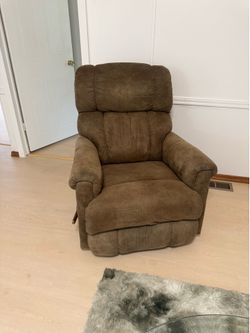 This brown La-Z-Boy recliner features a plush, segmented backrest and padded arms.
