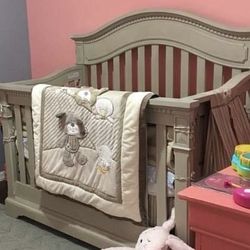 Convertible baby crib, includes mattress and bedding set.