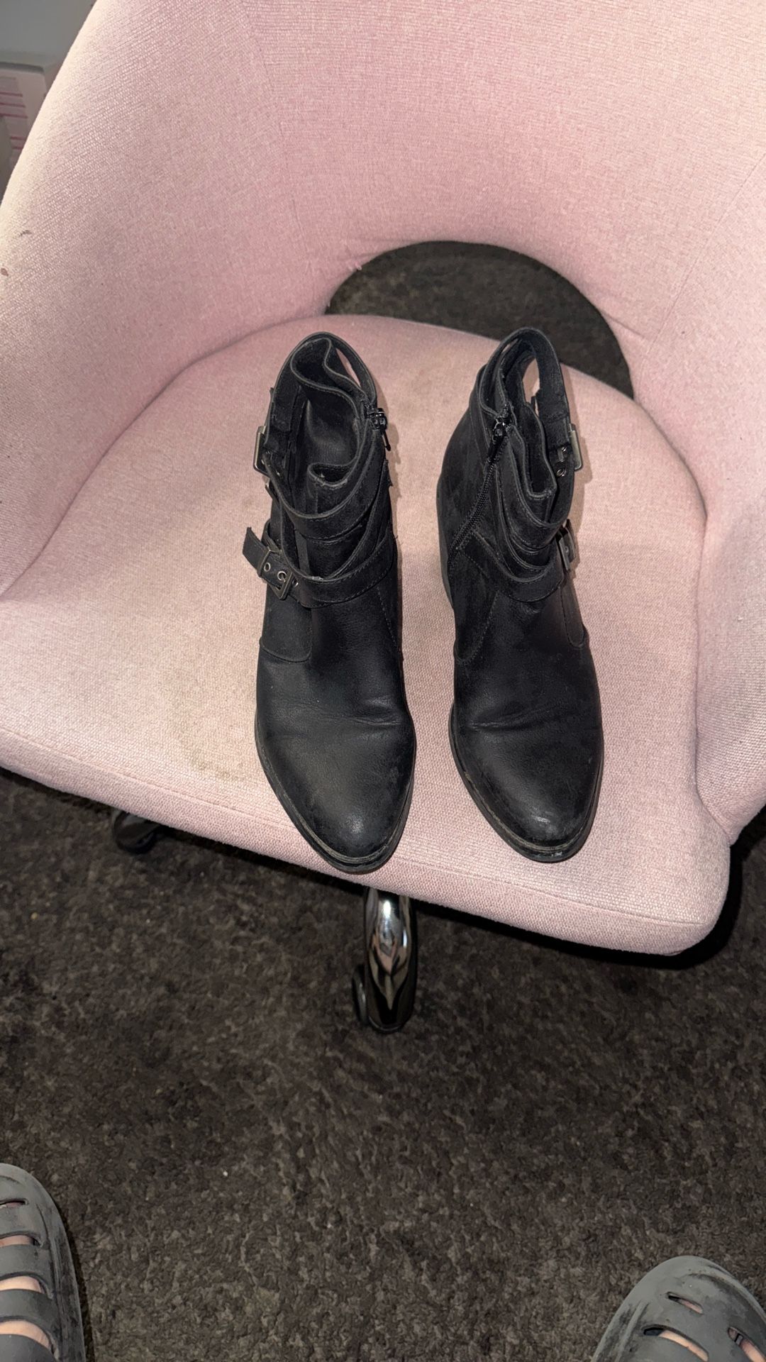 black leather ankle boots with buckle and zipper details.