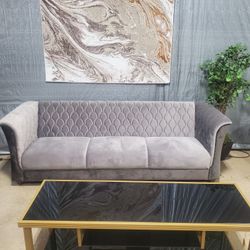 Gray Velvet Sofa With A Design On Back 