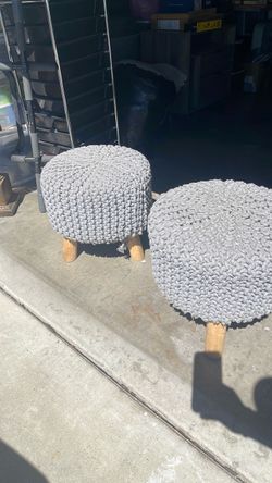 chunky knit grey pouf ottoman featuring a textured hand-knitted cotton cover and a wooden leg base.