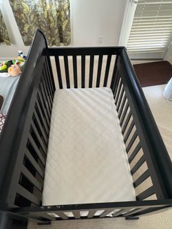 Baby crib with crib mattress and mattress protector
