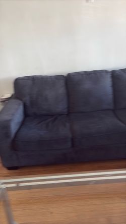 Blue sectional, and glass coffee table