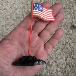 vintage plastic American flag toy often sold with toy soldiers or military vehicles, specifically resembling those produced by companies like Marx in 