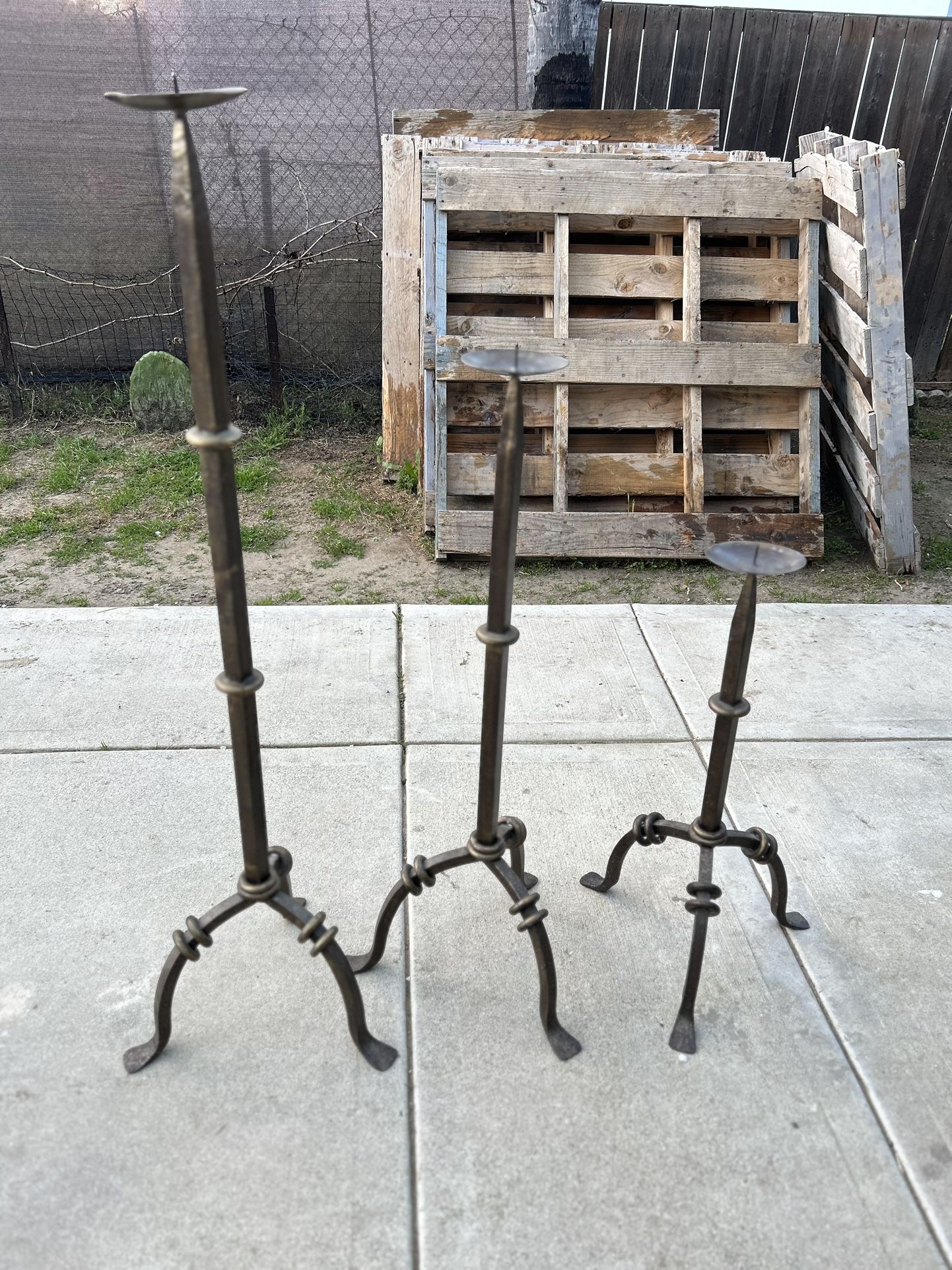 Three heavy iron candle holders