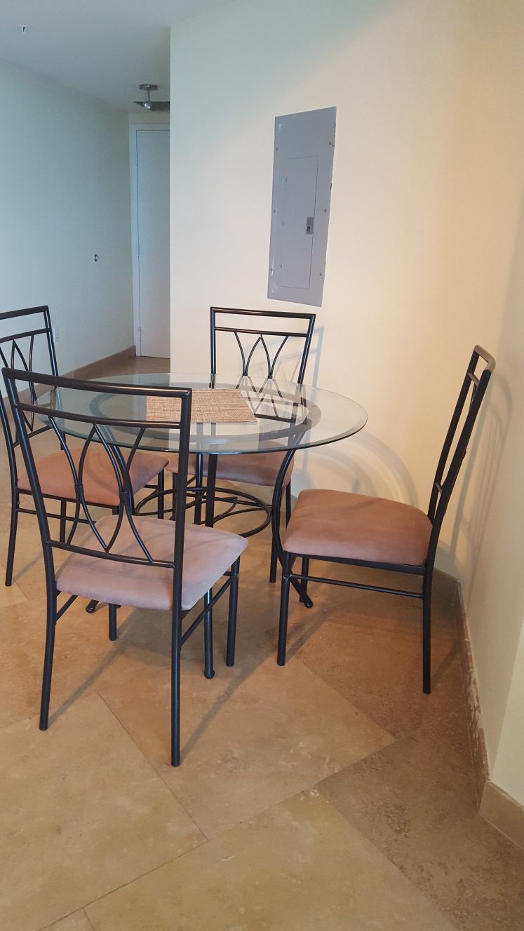 Dining set 4 suede padded chairs and round glass table.