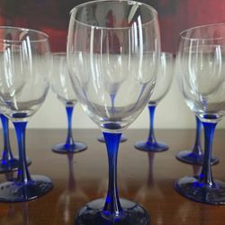Set of eight clear glass wine glasses with cobalt blue stems and bases, by Luminarc.
