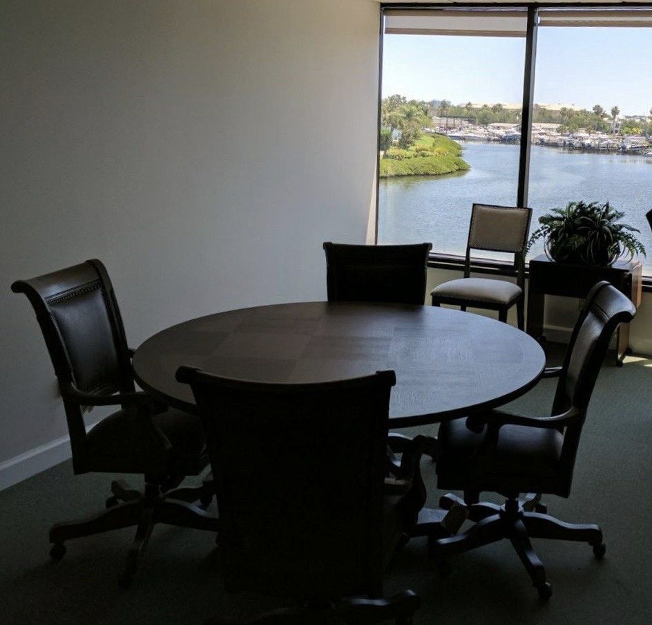 Four leather swivel office chairs.