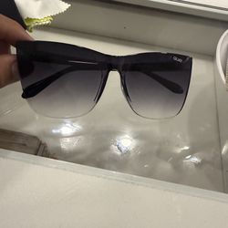 Quay sun glasses with a black fade into purple case