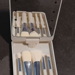 Compact with mirror and assorted make up brushes, lid can rotate, lights up by  round battery button. Used but not any of the brushes