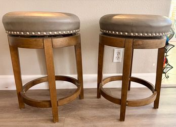 Two solid wood swivel counter stools