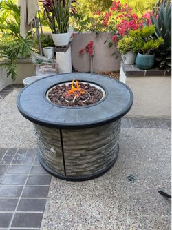 Fire pit table with a grey faux stone