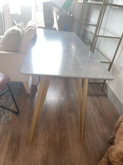 Cute grey modern table with gold legs.