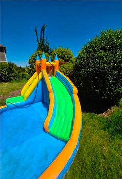 Used inflatable bouncy house/water slide. Includes blower & 12x16 heavy-duty waterproof tarp.