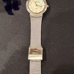 Skagen women's watch with a silver-tone stainless steel mesh band, a mother-of-pearl dial, and a crystal-accented bezel. The tag in the image includes