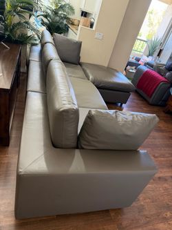 Gray vegan faux leather sectional sofa couch that is sink in soft/plush with adjustable foot ottoman