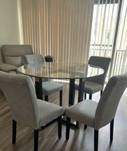 Round Glass Dining Table with Black Wood and Brass Base and Set of 4 Grey Tufted Upholstered Dining Chairs