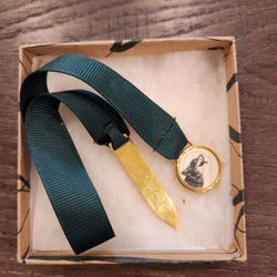 vintage bookmark in box featuring a green fabric ribbon and a small decorative charm at the end, good condition
