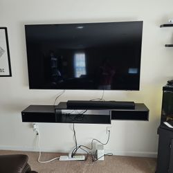 75' Samsung Flat Screen With Soundbar, Woofer, And Floating Shelf