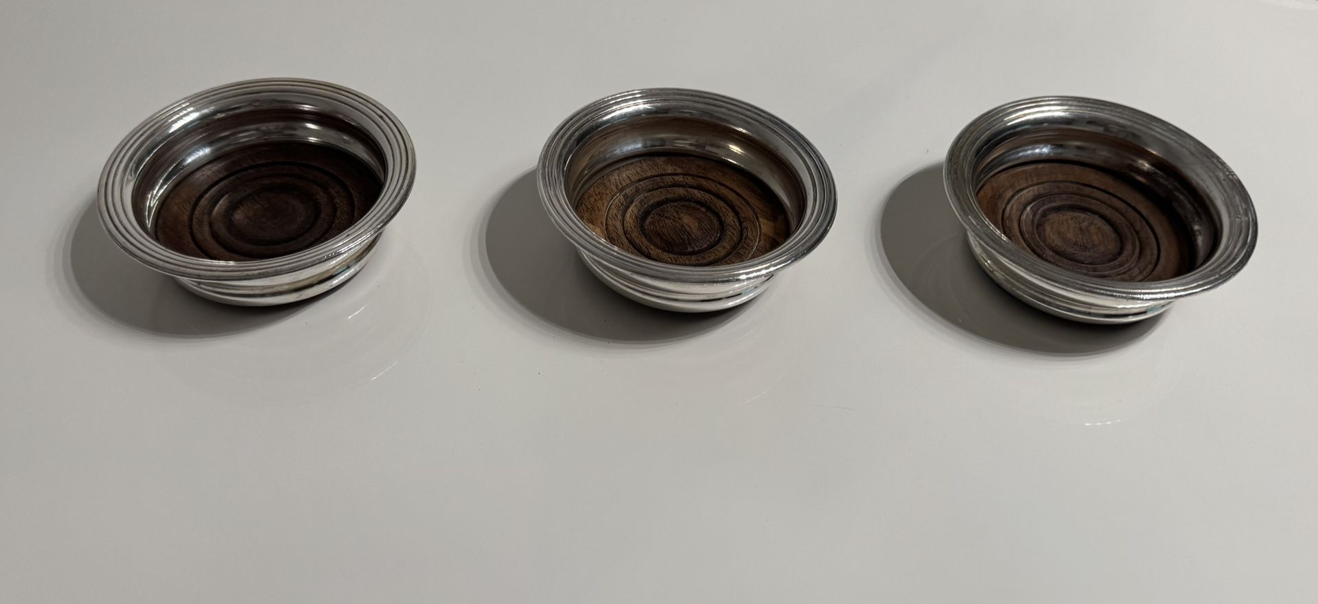 A Set Of 3 Antique Silver Plated Wine Bottle Coasters.