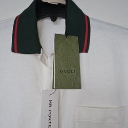 Stylish Gucci polo shirt in white with a green collar. 