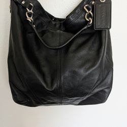 This is a pre-owned Coach Brooke hobo shoulder bag. Style #14821. It is soft black leather with silvertone hardware. 