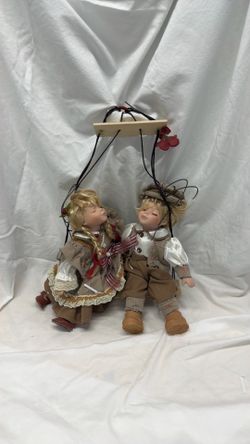 2 Vintage Porcelain dolls sitting on swing