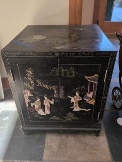 Vintage Chinese black lacquer cabinet with hand-painted scenes and mother-of-pearl inlay.