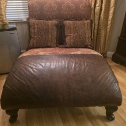 Brown leather and patterned fabric chaise lounge chair.