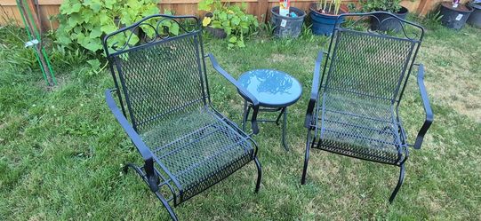 Two wroght iron chairs and a small table