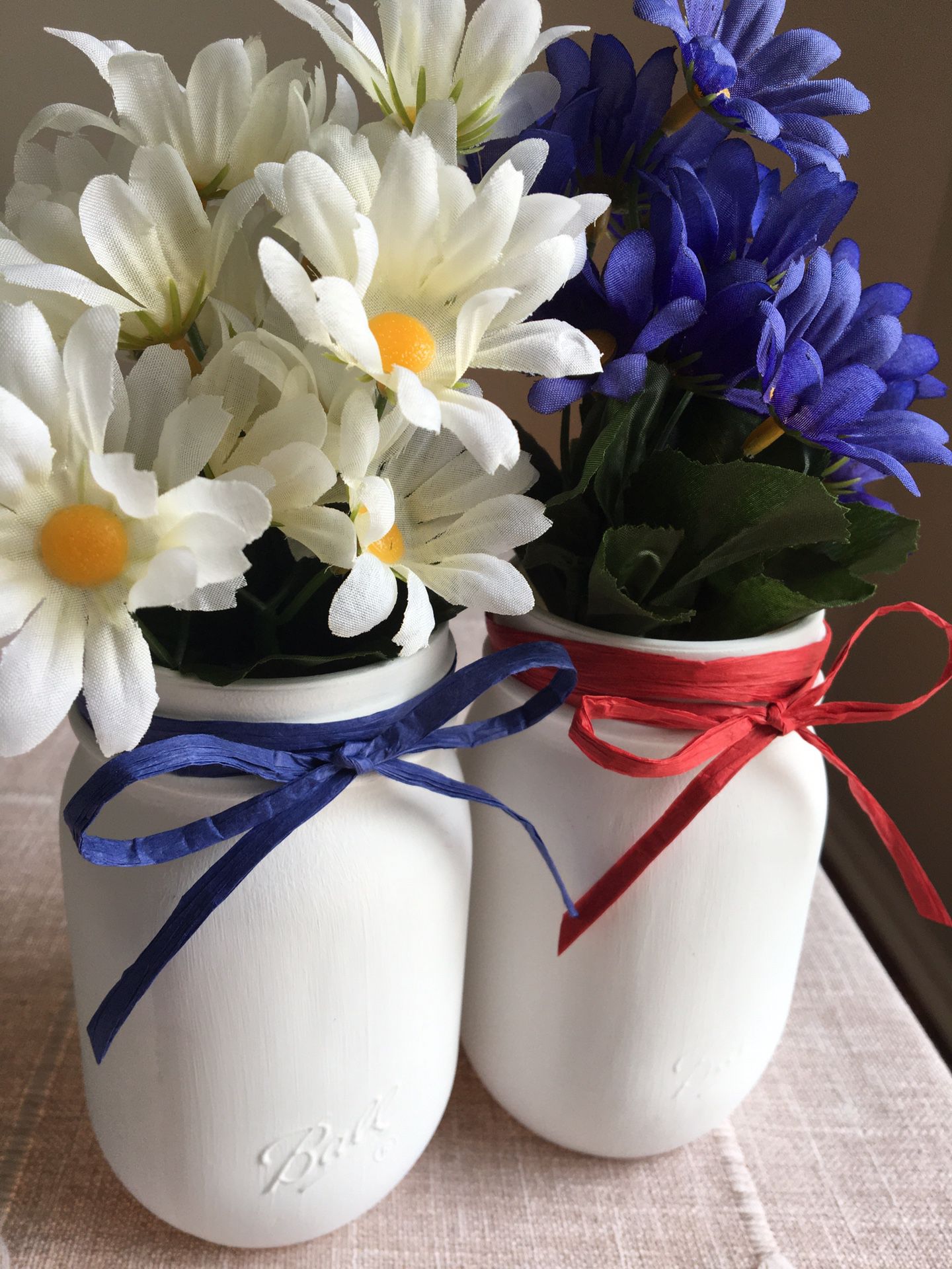 Two chalk painted mason jars with silk flowers