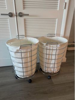 Two matching rolling laundry hampers