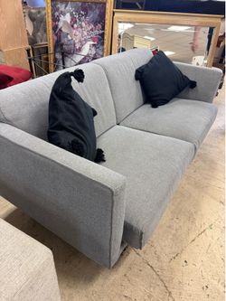 sofa features a modern, minimalist design in a neutral gray fabric - 82”