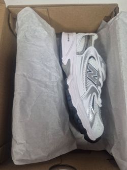 Kids New Balance 530 sneakers feature a white and metallic silver color scheme