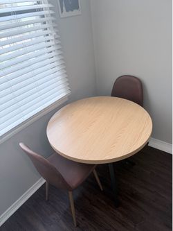 IKEA round table with two leather chairs